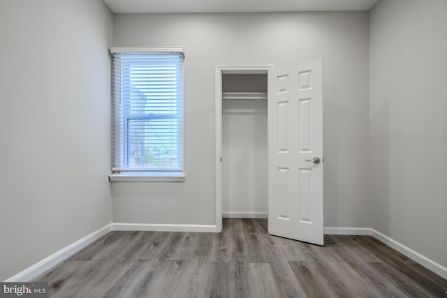 1229 N Potomac St, Baltimore, MD 21213 - unfurnished bedroom with wood finished floors, a closet, and baseboards