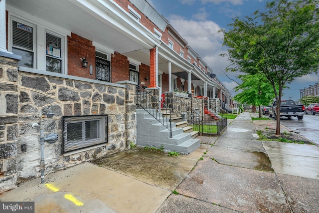 1229 N Potomac St, Baltimore, MD 21213 - property entrance with a porch, stone siding, and brick siding