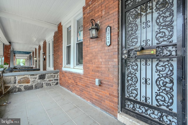 1229 N Potomac St, Baltimore, MD 21213 - property entrance featuring covered porch and brick siding