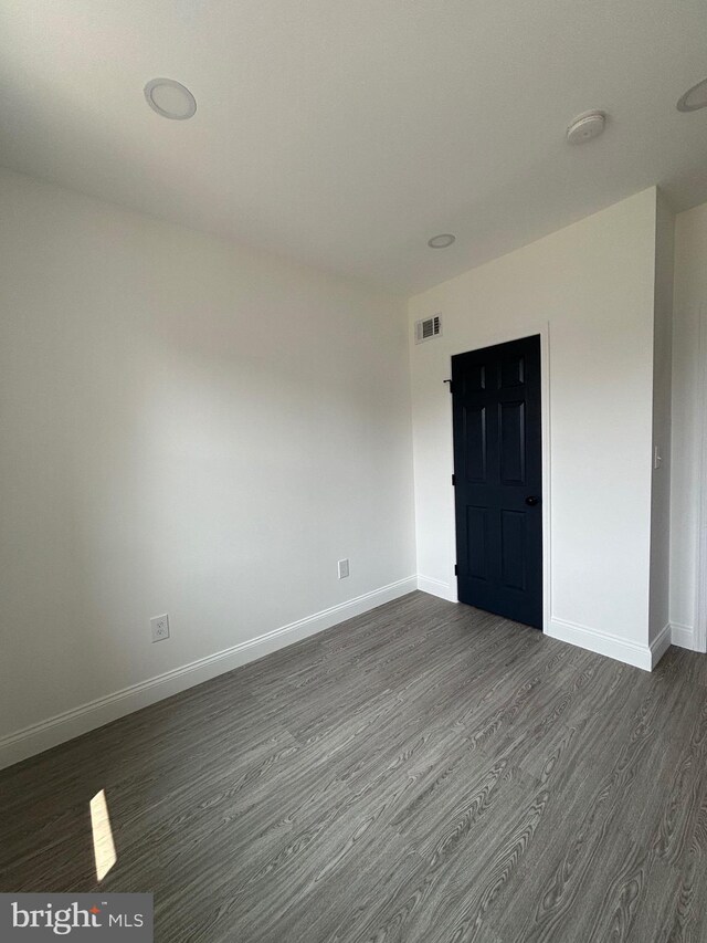 1748 N Chester St, Baltimore, MD 21213 - empty room featuring dark wood finished floors, baseboards, and a smoke detector
