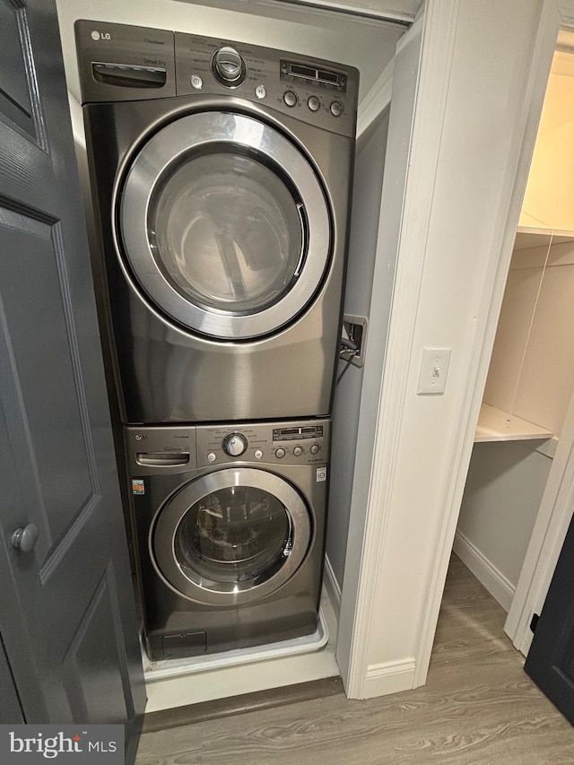 1748 N Chester St, Baltimore, MD 21213 - laundry area with stacked washer and clothes dryer, wood finished floors, and baseboards