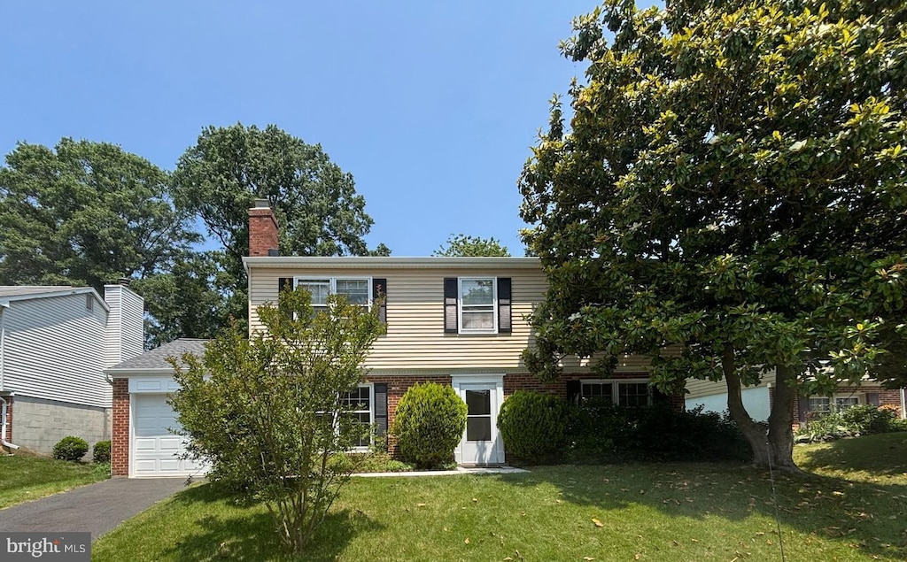 6819 Ben Franklin Rd, Springfield, VA 22150 - colonial home featuring brick siding, a front yard, a chimney, a garage, and driveway