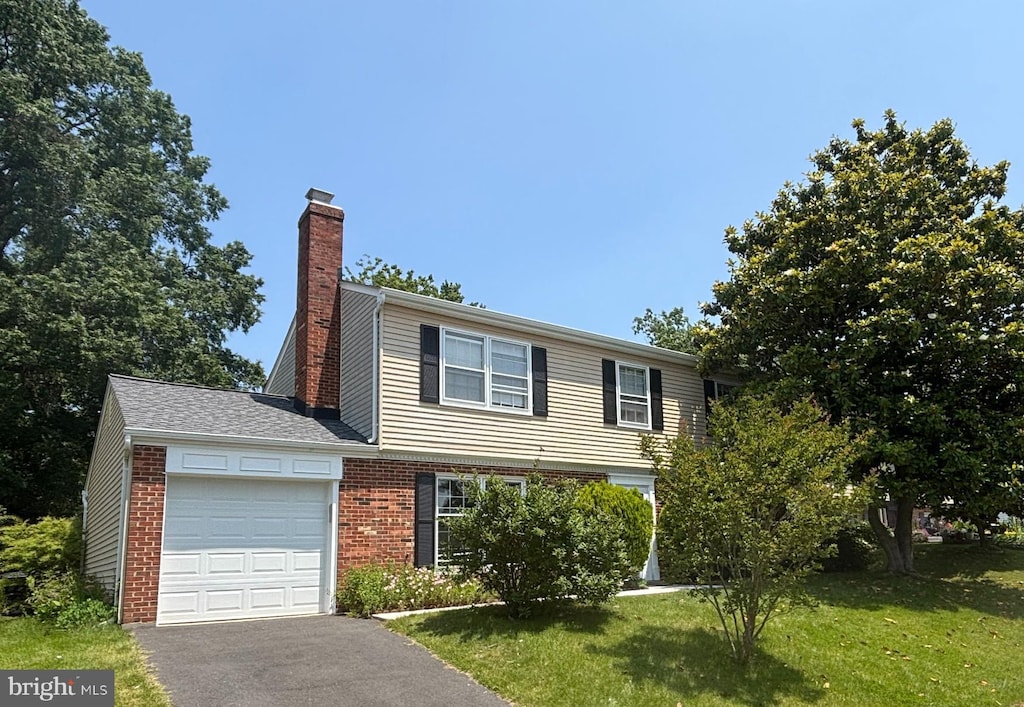 6819 Ben Franklin Rd, Springfield, VA 22150 - view of front facade with an attached garage, a chimney, brick siding, and a front yard