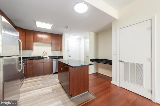 155 Potomac Psge Unit 429, Oxon Hill, MD 20745 - kitchen with stainless steel appliances, a sink, a center island, light wood-type flooring, and baseboards