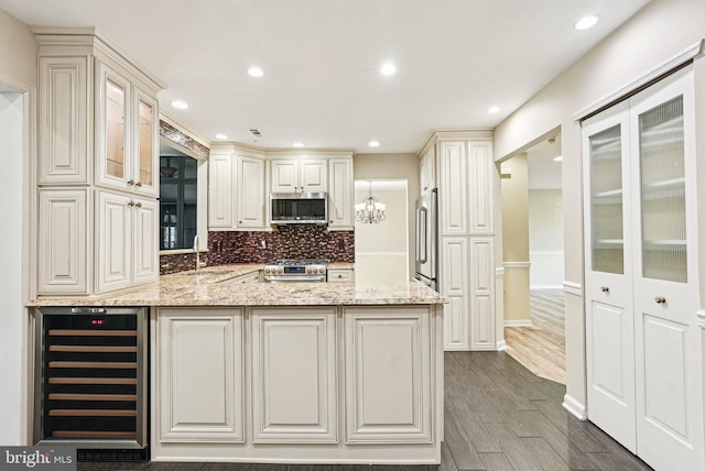 5 Locust Ln, Newtown, PA 18940 - kitchen featuring wine cooler, appliances with stainless steel finishes, a sink, decorative backsplash, and light stone counters