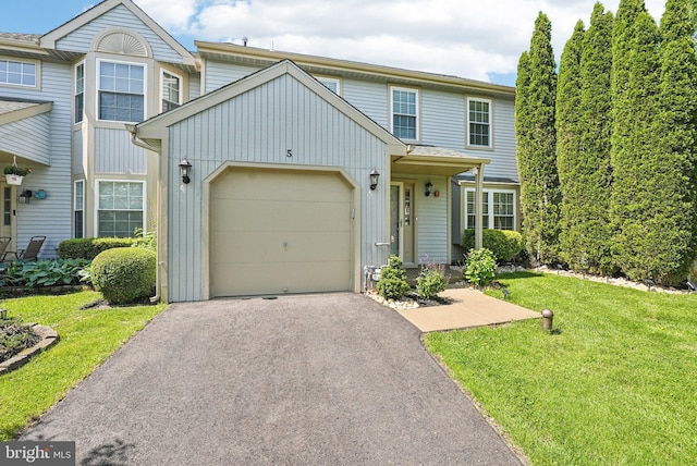 5 Locust Ln, Newtown, PA 18940 - view of front of property featuring asphalt driveway, board and batten siding, an attached garage, and a front yard