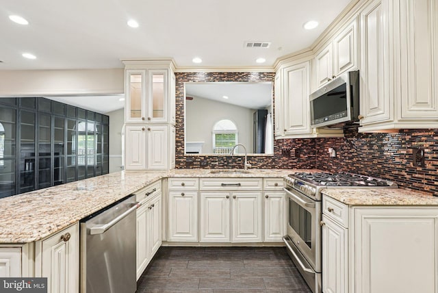 5 Locust Ln, Newtown, PA 18940 - kitchen with appliances with stainless steel finishes, a sink, tasteful backsplash, light stone countertops, and glass insert cabinets