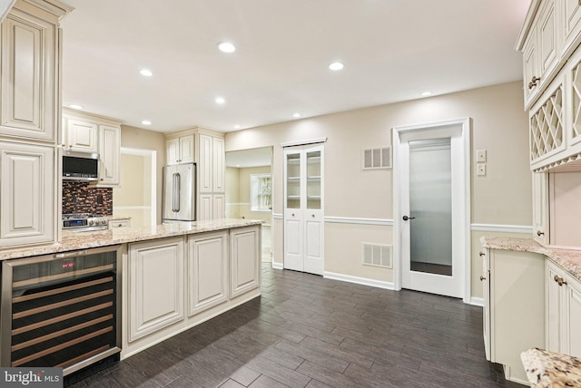 5 Locust Ln, Newtown, PA 18940 - kitchen featuring wine cooler, appliances with stainless steel finishes, backsplash, dark wood-style floors, and light stone countertops