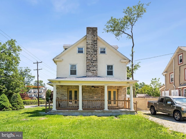 285 N Lansdowne Ave, Lansdowne, PA 19050 - rear view of house with french doors, stone siding, a lawn, and stucco siding