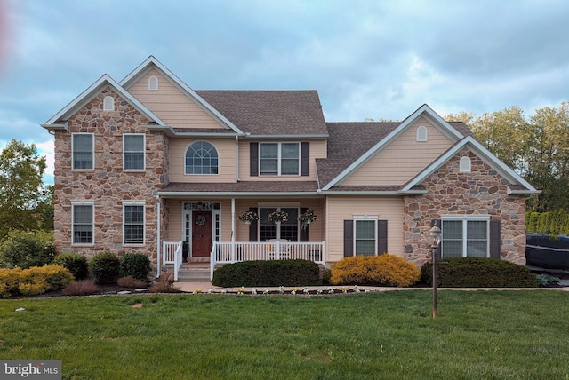 35 Krall Rd, Myerstown, PA 17067 - view of front facade with stone siding, covered porch, a front lawn, and roof with shingles
