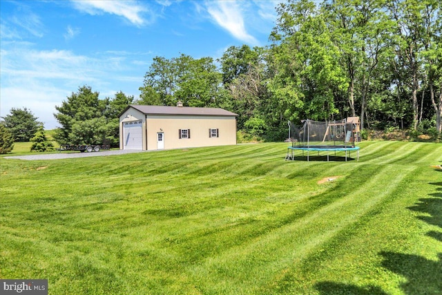 35 Krall Rd, Myerstown, PA 17067 - view of grassy yard featuring a trampoline, an outbuilding, a garage, and view of wooded area