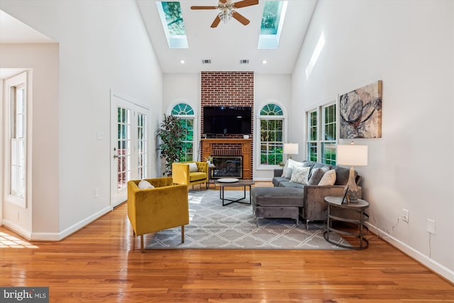 19802 Shady Brook Way, Gaithersburg, MD 20879 - living area featuring high vaulted ceiling, a ceiling fan, light wood-style floors, a skylight, and a brick fireplace