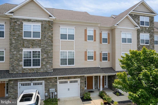 126 Backstretch Way, Prince Frederick, MD 20678 - multi unit property with stone siding, an attached garage, driveway, and roof with shingles