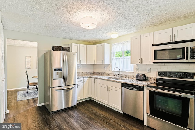 6786 Singletree Ct, Frederick, MD 21703 - kitchen with stainless steel appliances, a sink, dark wood-style floors, white cabinets, and light stone countertops