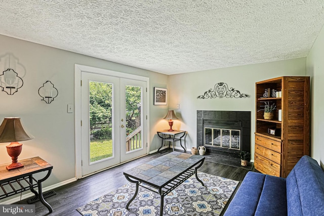 6786 Singletree Ct, Frederick, MD 21703 - living room featuring wood finished floors, a tile fireplace, a textured ceiling, and french doors
