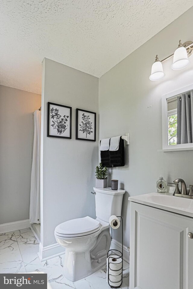 6786 Singletree Ct, Frederick, MD 21703 - bathroom featuring toilet, marble look tile flooring, vanity, a stall shower, and a textured ceiling