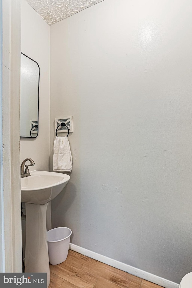 6786 Singletree Ct, Frederick, MD 21703 - half bathroom featuring baseboards, wood finished floors, a textured ceiling, and a sink