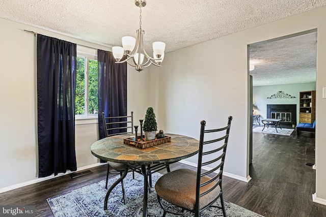 6786 Singletree Ct, Frederick, MD 21703 - dining space featuring a textured ceiling, a chandelier, wood finished floors, baseboards, and a glass covered fireplace