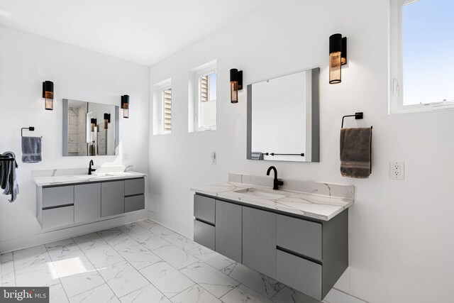 2206 E Fletcher St, Philadelphia, PA 19125 - bathroom featuring two vanities, marble finish flooring, healthy amount of natural light, and baseboards