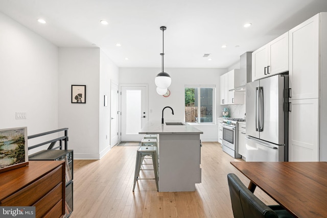 2206 E Fletcher St, Philadelphia, PA 19125 - kitchen with appliances with stainless steel finishes, white cabinetry, a sink, a kitchen island with sink, and light wood-style flooring