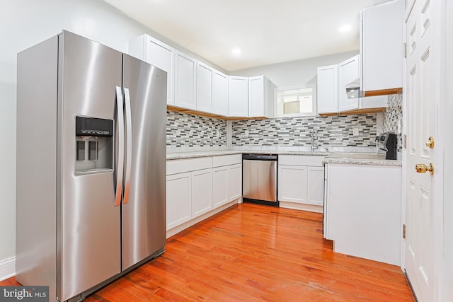 802 W Ritner St, Philadelphia, PA 19148 - kitchen featuring appliances with stainless steel finishes, white cabinets, tasteful backsplash, light wood-style flooring, and recessed lighting