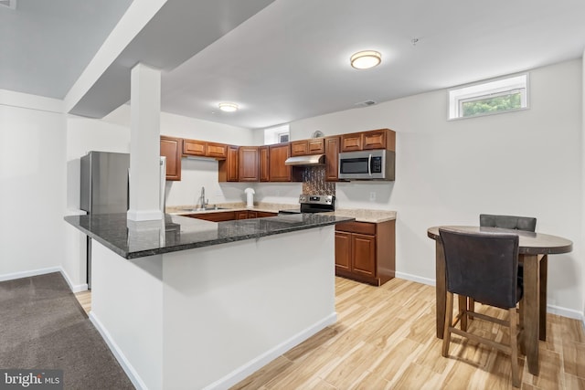 12916 Steam Mill Farm Dr, Brandywine, MD 20613 - kitchen featuring stainless steel appliances, under cabinet range hood, a sink, dark stone countertops, and baseboards