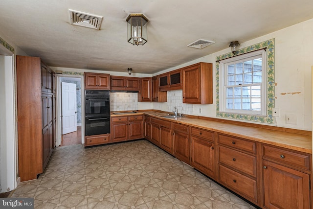 100 Carson Rd, Princeton, NJ 08540 - kitchen with black appliances, a sink, brown cabinets, decorative backsplash, and light countertops