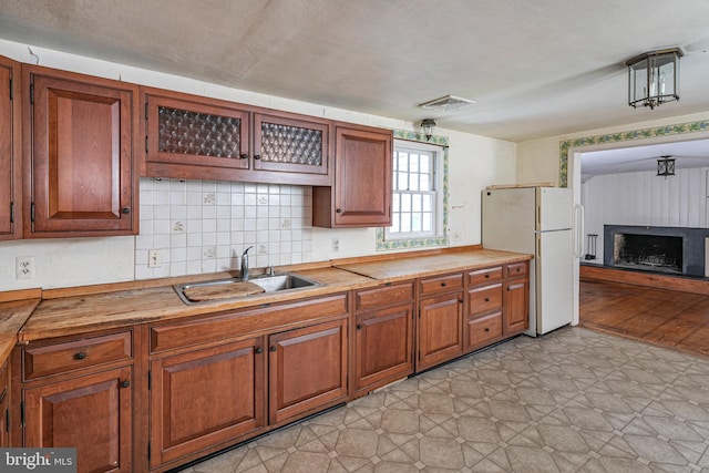 100 Carson Rd, Princeton, NJ 08540 - kitchen featuring freestanding refrigerator, a sink, and brown cabinetry