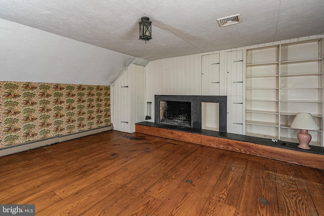 100 Carson Rd, Princeton, NJ 08540 - unfurnished living room featuring wood finished floors, vaulted ceiling, a fireplace with raised hearth, a textured ceiling, and baseboard heating
