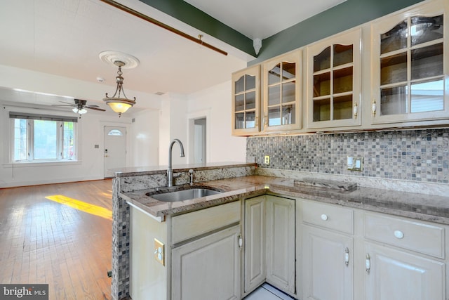 5919 Sefton Ave, Baltimore, MD 21214 - kitchen featuring a sink, a peninsula, a ceiling fan, backsplash, and beamed ceiling