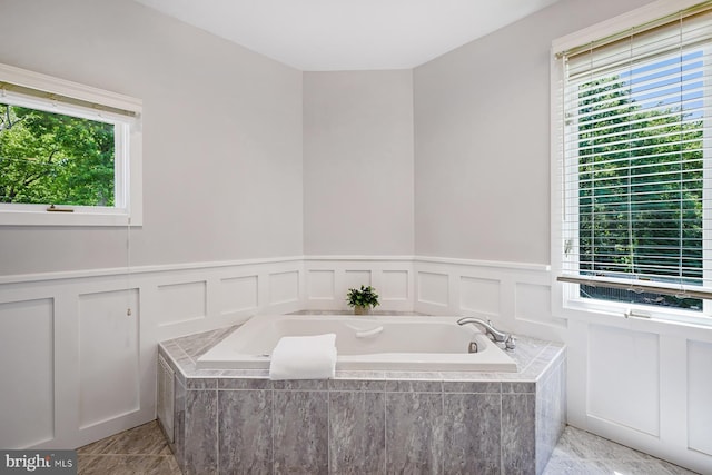 3442 Rockway Ave, Annapolis, MD 21403 - bathroom featuring a bath, a decorative wall, plenty of natural light, a wainscoted wall, and tile patterned floors