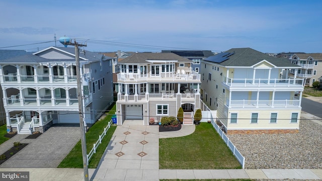 1107 Ocean Ave, Brigantine, NJ 08203 - view of front facade with an attached garage, concrete driveway, a residential view, and a balcony