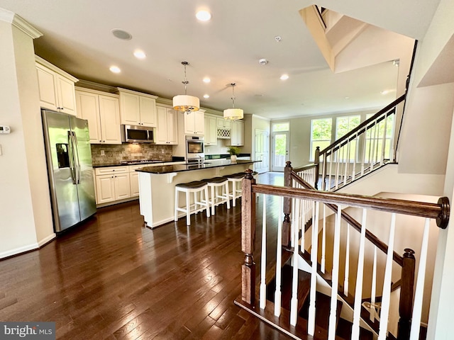 6967 Country Club Ter, New Market, MD 21774 - kitchen featuring appliances with stainless steel finishes, recessed lighting, dark countertops, decorative backsplash, and a kitchen breakfast bar