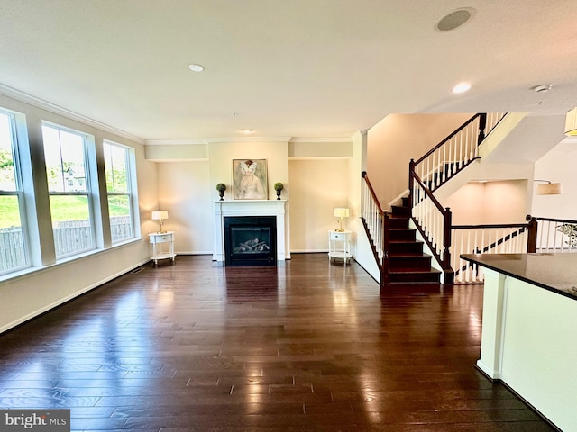 6967 Country Club Ter, New Market, MD 21774 - unfurnished living room featuring dark wood-type flooring, ornamental molding, a glass covered fireplace, and stairway