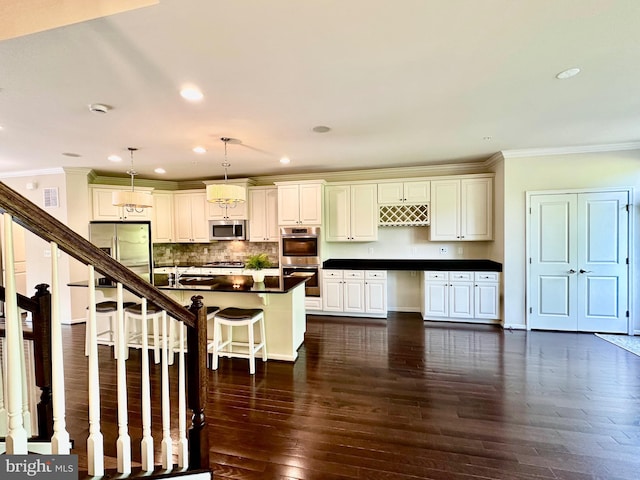 6967 Country Club Ter, New Market, MD 21774 - kitchen featuring appliances with stainless steel finishes, dark countertops, ornamental molding, a kitchen breakfast bar, and tasteful backsplash