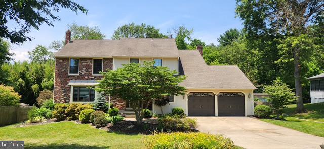 64 Pelham Dr, Mantua, NJ 08051 - view of front facade with an attached garage, a chimney, concrete driveway, and a front lawn