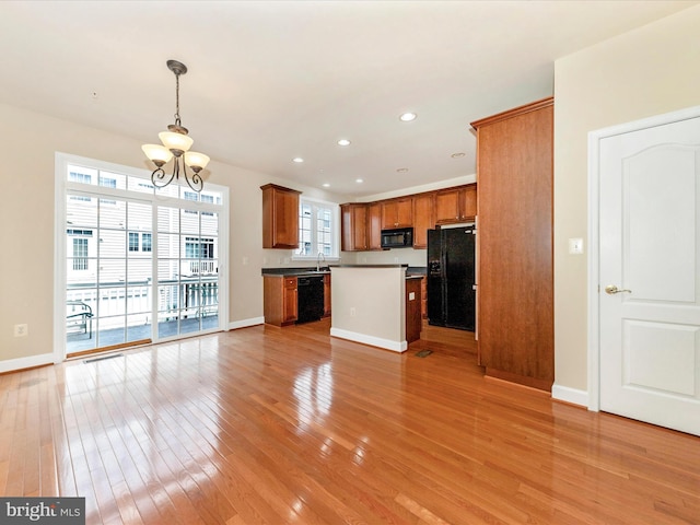 739 Hidden Marsh St, Gaithersburg, MD 20877 - kitchen with black appliances, a chandelier, brown cabinetry, light wood-style flooring, and recessed lighting