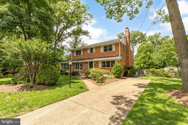 5404 Nedra Ave, Alexandria, VA 22310 - traditional home with concrete driveway, a chimney, brick siding, and a front yard