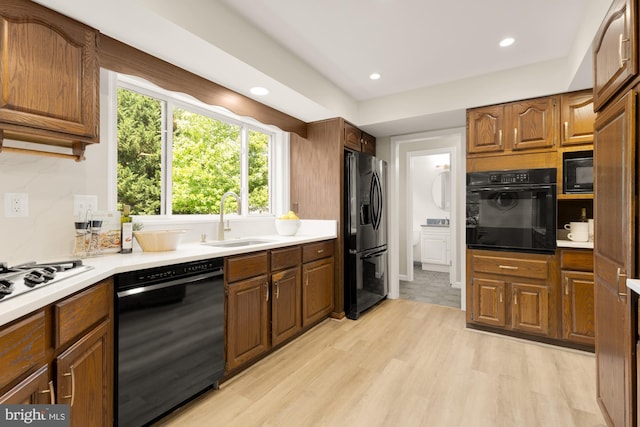 5404 Nedra Ave, Alexandria, VA 22310 - kitchen with black appliances, a sink, light countertops, light wood-style floors, and recessed lighting