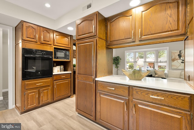 5404 Nedra Ave, Alexandria, VA 22310 - kitchen featuring black appliances, brown cabinets, light wood finished floors, light countertops, and recessed lighting