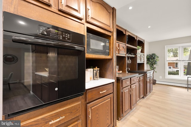 5404 Nedra Ave, Alexandria, VA 22310 - kitchen featuring black microwave, a baseboard heating unit, light wood-style flooring, brown cabinets, and recessed lighting