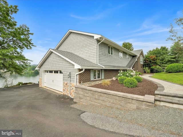 2054 Buckskin Cv, Auburn, PA 17922 - view of side of home with a garage, asphalt driveway, a water view, a shingled roof, and stone siding
