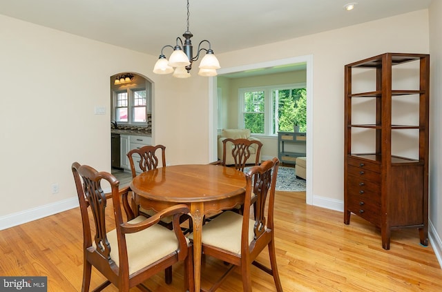 921 Coopertown Rd, Bryn Mawr, PA 19010 - dining space with light wood-style flooring, a chandelier, baseboards, recessed lighting, and arched walkways