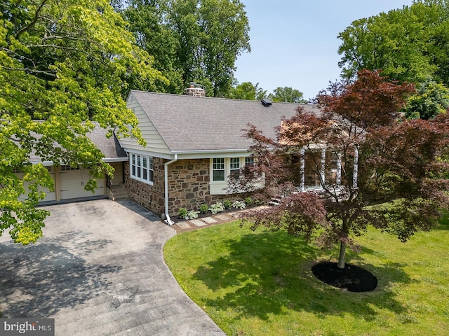 921 Coopertown Rd, Bryn Mawr, PA 19010 - view of front of home with stone siding, a shingled roof, asphalt driveway, a front lawn, and a chimney
