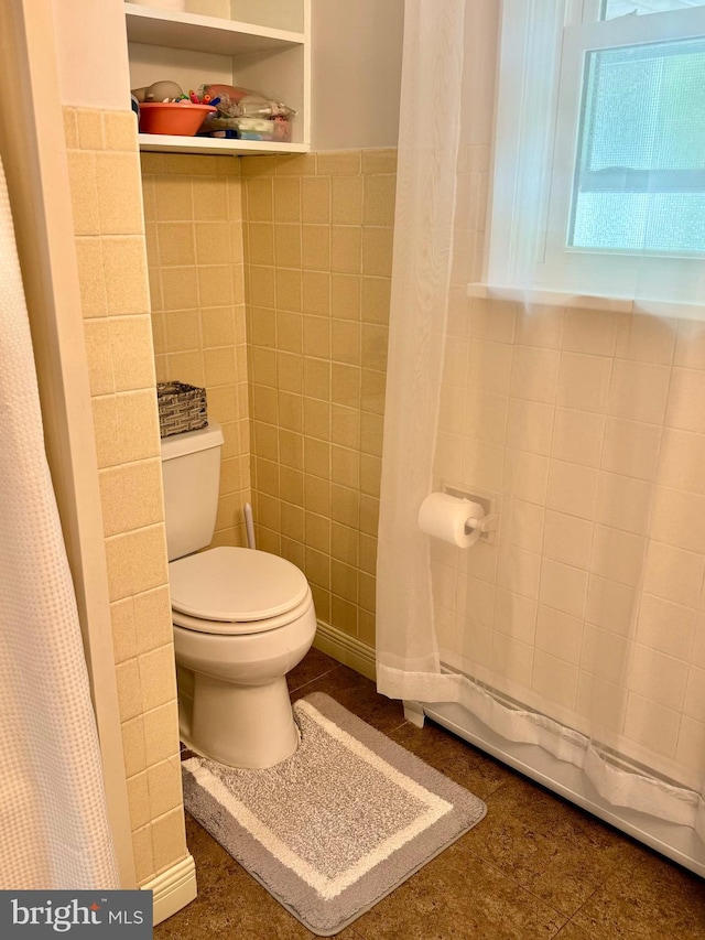 701 25th St, Huntingdon, PA 16652 - bathroom featuring tile walls, toilet, and a shower with shower curtain