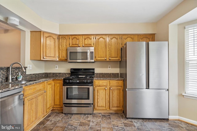 205 Quiet Ridge Ct, Pasadena, MD 21122 - kitchen featuring stainless steel appliances, a sink, dark stone counters, and baseboards