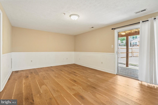205 Quiet Ridge Ct, Pasadena, MD 21122 - spare room featuring wood finished floors, wainscoting, and a textured ceiling