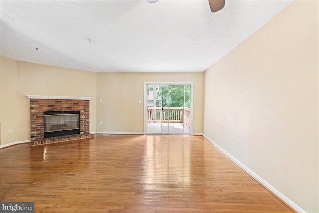 205 Quiet Ridge Ct, Pasadena, MD 21122 - unfurnished living room featuring wood finished floors, baseboards, ceiling fan, and a brick fireplace