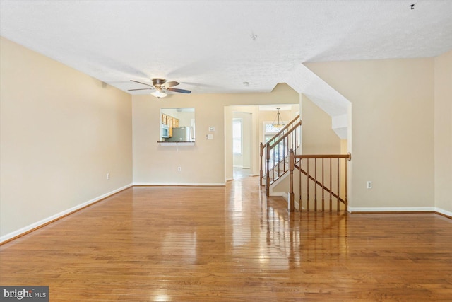 205 Quiet Ridge Ct, Pasadena, MD 21122 - unfurnished living room with wood finished floors, ceiling fan, baseboards, and stairway