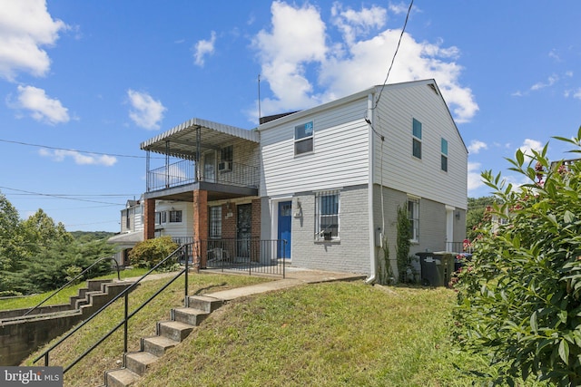 844 51st St NE, Washington, DC 20019 - back of property with a balcony, brick siding, and a lawn